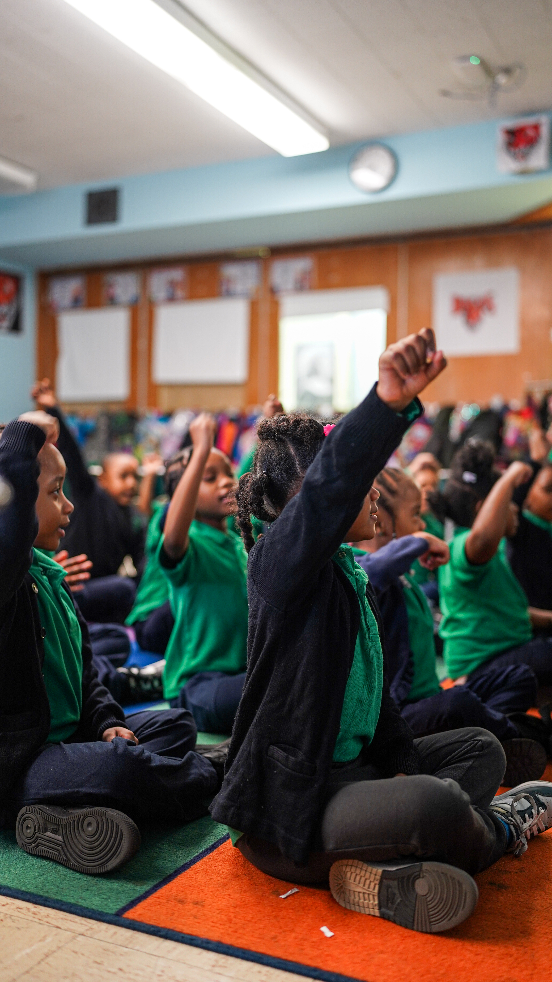 Students raising hands in classroom